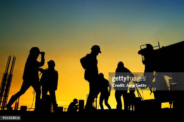 silhouette construction worker concrete pouring during commercial concreting floors of building in construction site and civil engineer inspection work - work silhouette stockfoto's en -beelden