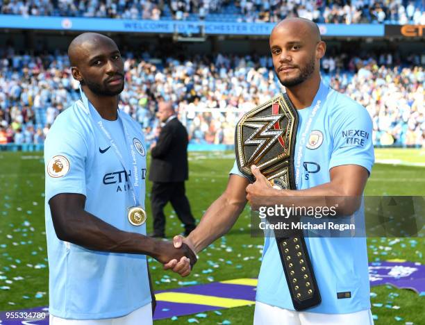 Eliaquim Mangala of Manchester City and Yaya Toure of Manchester City shake hands on the pitch with a WWE belt after the Premier League match between...