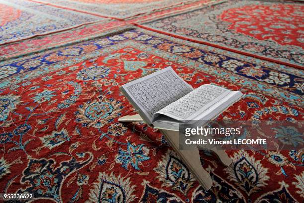 Un coran repose ouvert sur un chevalet à l?intérieur de la mosquée du village de Faraj, Iran, sur fond de tapis persans, en avril 2015.