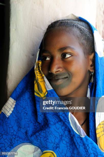 Jeune femme à la porte d'une habitation dans le village Sendégué, 8 janvier 2009, Mali.