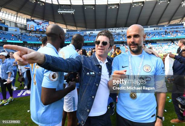 Noel Gallagher speaks to Josep Guardiola, Manager of Manchester City on the pitch after the Premier League match between Manchester City and...
