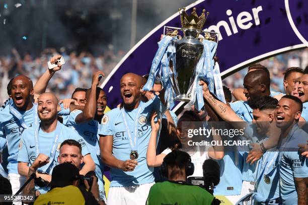 Manchester City's captian, Belgian defender Vincent Kompany lifts the Premier League trophy on the pitch after the English Premier League football...