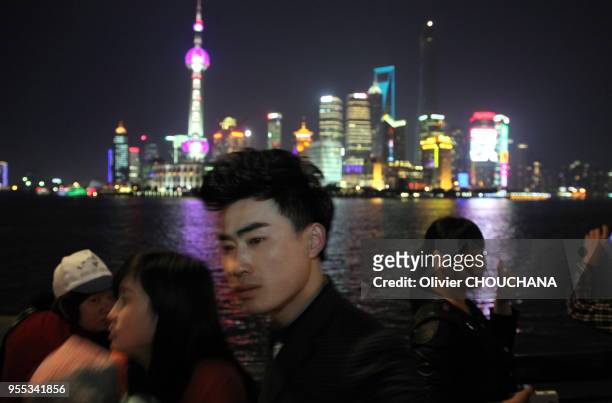 Des touristes chinois visitent de nuit les grattes ciels illuminés de Pudong, le célèbre quartier d'affaires de la ville le 1 Avril 2014 à Shanghai,...