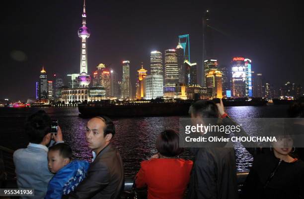 Des touristes chinois visitent et photographient de nuit les grattes ciels illuminés de Pudong, le célèbre quartier d'affaires de la ville le 1 Avril...
