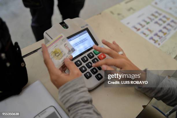 National Electoral Council official tests a verification machine on an ID card, on May 6 in Caracas, Venezuela, during a preparatory rehearsal for...