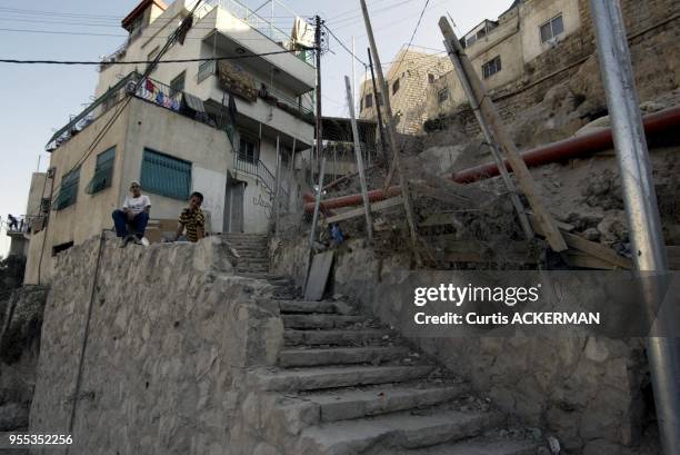 Two Israeli Arab boys sit on wall in the East Jerusalem village of Silwan on Saturday June 4, 2005. The Knesset will Wednesday debate an urgent...