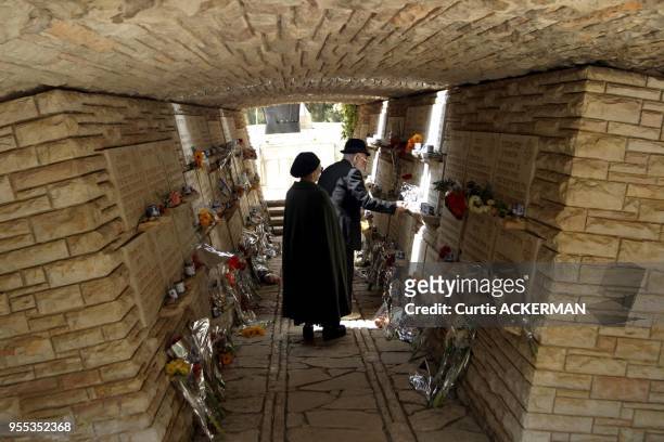An elderly couple place a flower at the memorial for fallen Navy submariners at Mt. Herzl Military Cemetery in Jerusalem on Wednesday, May 11, 2005....