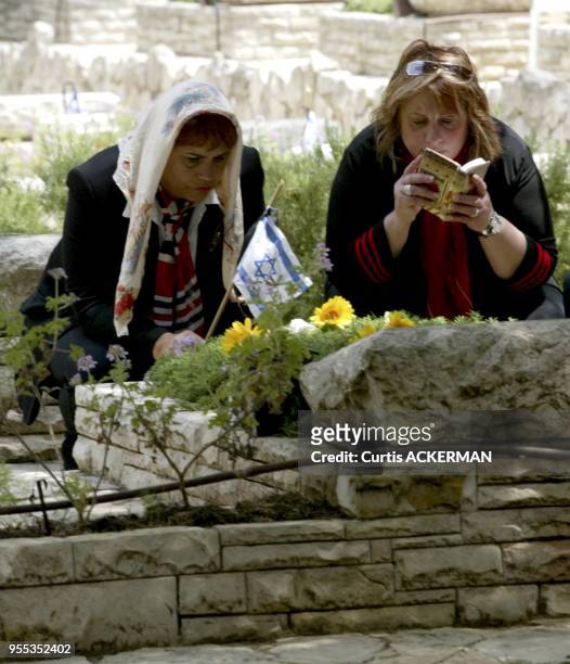 Two women pray at the grave of a loved one at Mt. Herzl Military Cemetery in Jerusalem on Wednesday, May 11, 2005. Israel is observing its Memorial...