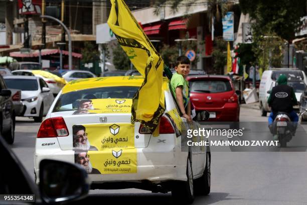 Supporters of the Shiite Muslim Hezbollah movement tour the city of Nabatieh in southern Lebanon on May 6 as the country votes in its first...