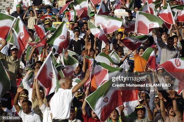 Iranian fans cheer during their National team's Group B Asian zone 2006 world cup qualifyer match against North Korea at the Azadi Stadium in Tehran....