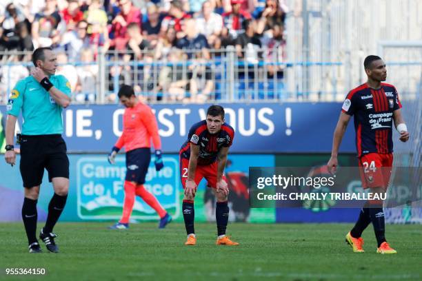 French referee Ruddy Buquet, Caen's French defender Frederic Guilbert and Caen's French defender Alexander Djiku are seen during the French L1...