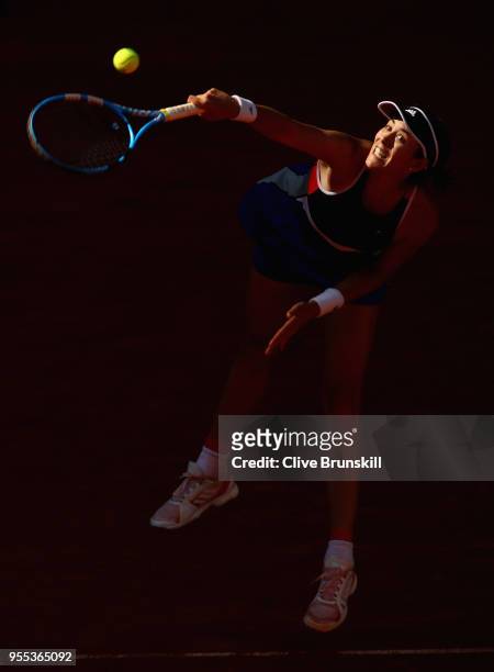 Garbine Muguruza of Spain serves against Shuai Peng of China in their first round match during day two of the Mutua Madrid Open tennis tournament at...