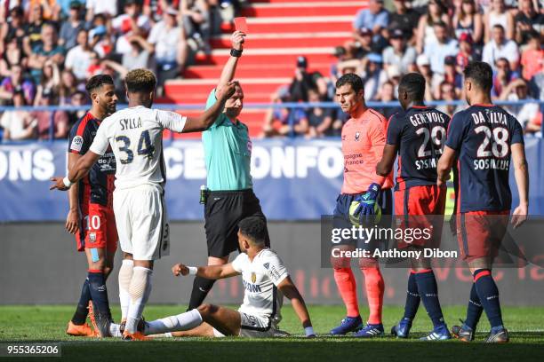 Referee Ruddy Buquet gives a red card to Romain Genevois of Caen during the Ligue 1 match between SM Caen and AS Monaco at Stade Michel D'Ornano on...