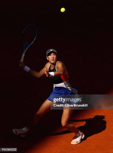 Garbine Muguruza of Spain looks up at a high ball as she gets ready to play a forehand against Shuai Peng of China in their first round match during...