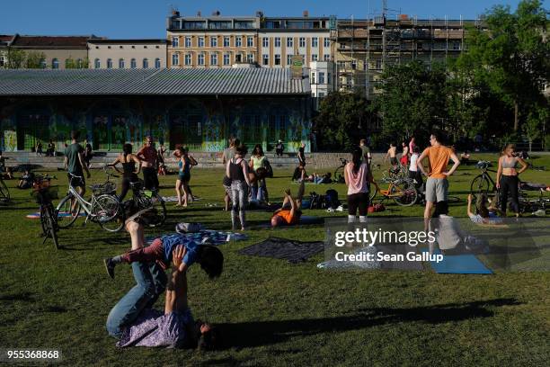 People attend an acrobalance class in Goerlitzer Park in Kreuzberg district on May 6, 2018 in Berlin, Germany. Sunny and summer-like weather drew...