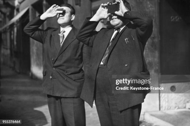 Deux hommes munis de verres fumés observent l'éclipse solaire à Bruxelles, Belgique.