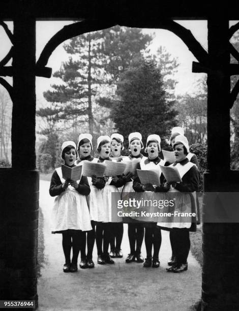 Les enfants de l'Hospice pour enfants trouvés répètent les chants de Noël dans le jardin, à Redhill, Royaume-Uni.