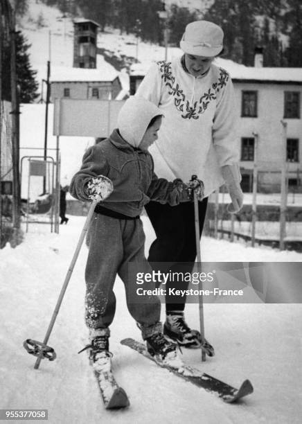 Enfant sur des ski accompagné par sa maman à Saint-Moritz, Suisse.