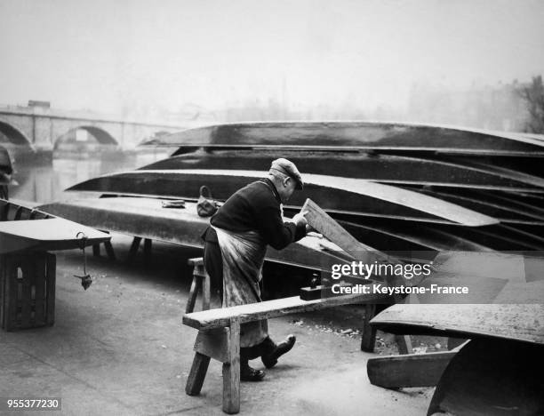 Un charpentier remet en état les bateaux à Richmond, Royaume-Uni.