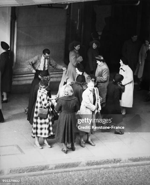 Regroupement de femmes autour du vendeur de bas nylon dans les rues de Londres, Royaume-Uni.