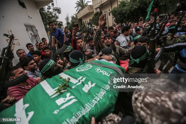 Members of Izz ad-Din al-Qassam Brigades, which is the military wing of the Palestinian Hamas organization, carry the dead body of Beha Abdurrahman...