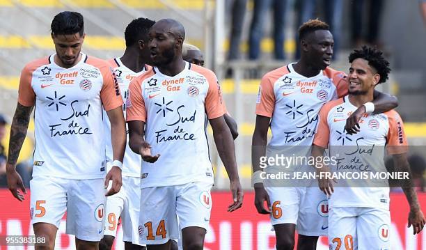 Montpellier's South African forward Keagan Dolly is congratulated by Montpellier's French midfielder Junior Sambia after scoring a goal during the...
