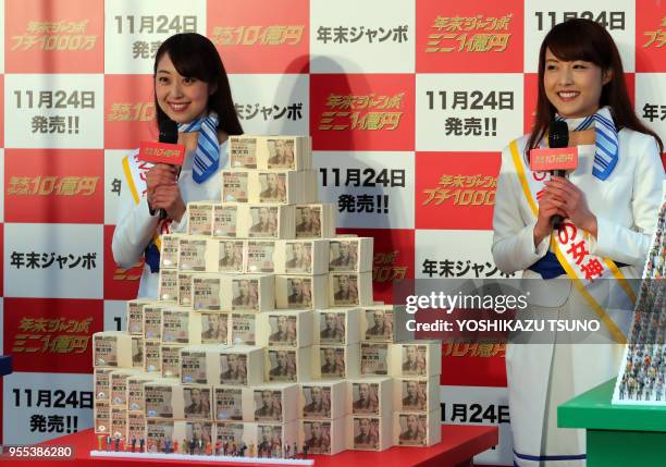 Campaign girls Eri Tatsuke and Yuri Takayama display one billion yen in cash for the "Year-end Jumbo Lottery" as the first tickets go on sale in...