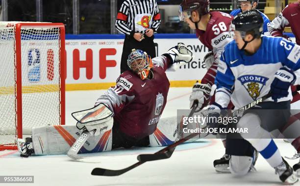 Latvia's goalkeeper Kristers Gudlevskis stops the puck during the group B match Latvia vs Finland of the 2018 IIHF Ice Hockey World Championship at...