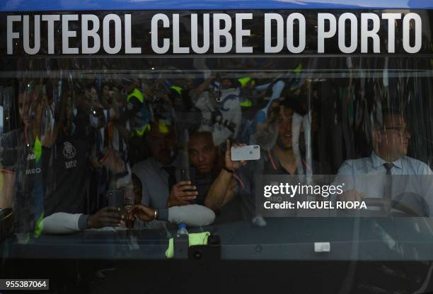 Porto's Algerian forward Yacine Brahimi takes pictures of Porto's supporters greeting the team bus outside the Dragao stadium in Porto ahead of the...