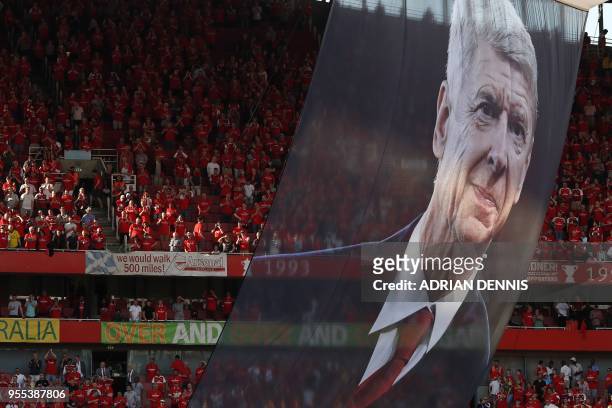 Large photograph of Arsenal's French manager Arsene Wenger is suspended from the roof as players take a lap of honour on the pitch after the English...