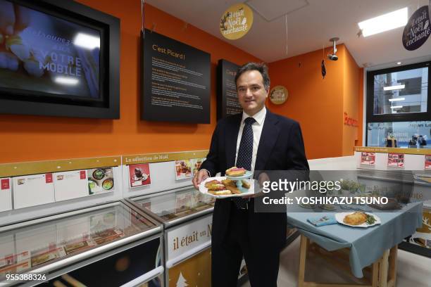 French food giant Picard international director Stefano Moretti displays a dish of eclairs at a press preview of Picard's first shop in Tokyo on...