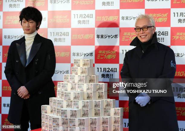 Japanese actors Go Ayano and Geoge Tokoro display one billion yen in cash for the "Year-end Jumbo Lottery" as the first tickets go on sale in Tokyo...