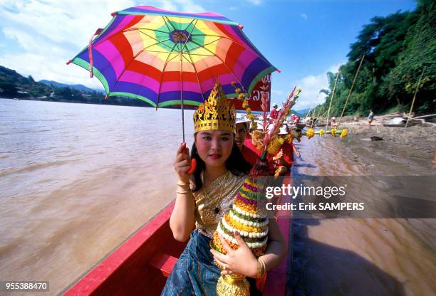 Une jeune fille un trophée aux couleurs de son équipe durant la fête des pirogues, circa 2000, en bordure du Mekong, Laos.