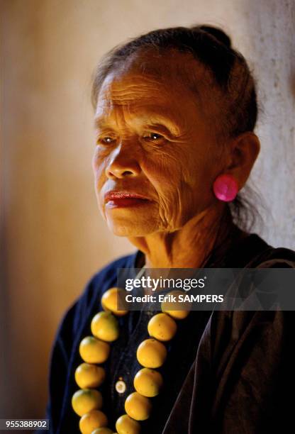 Portrait d'une femme agée maquillée avec un collier durant la fête des pirogues, circa 2000, Luang Prabang, Laos.