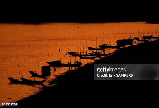 Pirogues au coucher du soleil durant la fête des pirogues, circa 2000, en bordure du Mekong, Laos.