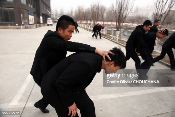 De jeunes recrues durant un entrainement intensif au métier de garde du corps dans un centre de formation de la banlieue de Pékin le 15 mars 2014 à...