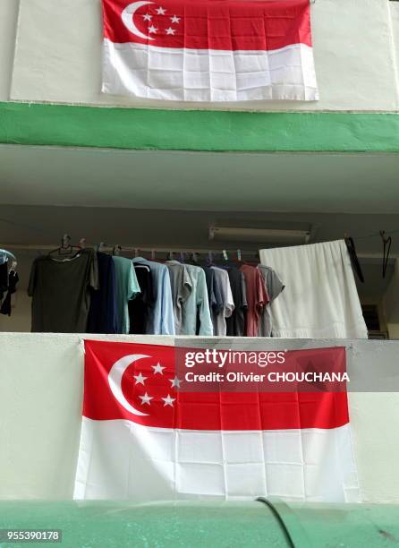 Drapeaux nationaux de Singapour pendus au balcon des immeubles de la ville-etat en preparation des commemorations du 9 aout 2015 pour celebrer le...