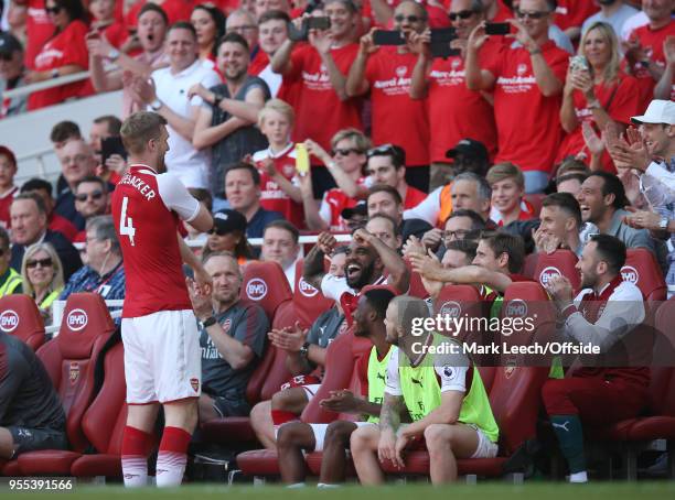 Arsenal teammates tease Per Mertesacker as he prepares to come on as a substitute during the Premier League match between Arsenal and Burnley at...