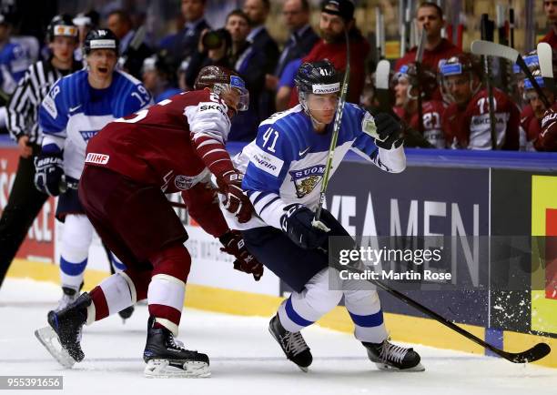 Andris Dzerins of Latvia and Miro Heiskanen of Finland battle for the puck during the 2018 IIHF Ice Hockey World Championship group stage game...