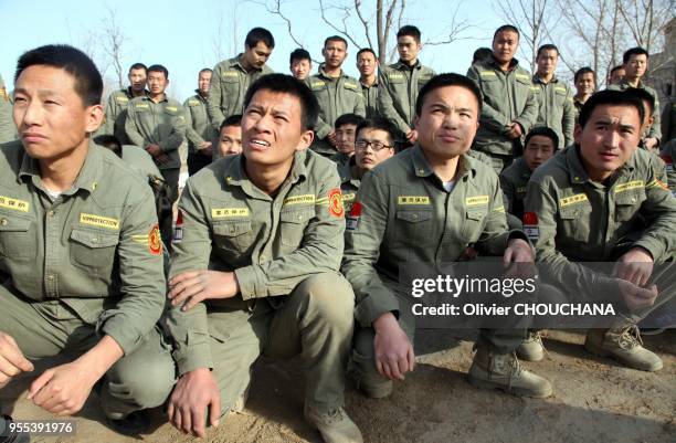 De jeunes recrues durant un entrainement intensif au métier de garde du corps dans un centre de formation de la banlieue de Pékin le 15 mars 2014 à...