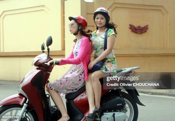 Une conductrice de scooter et une jeune femme à l'arriere scooter assise en amazone, le 9 Avril 2017, Hanoi, Vietnam.