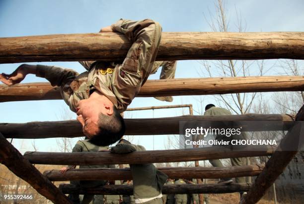 De jeunes recrues durant un entrainement intensif au métier de garde du corps dans un centre de formation de la banlieue de Pékin le 15 mars 2014 à...