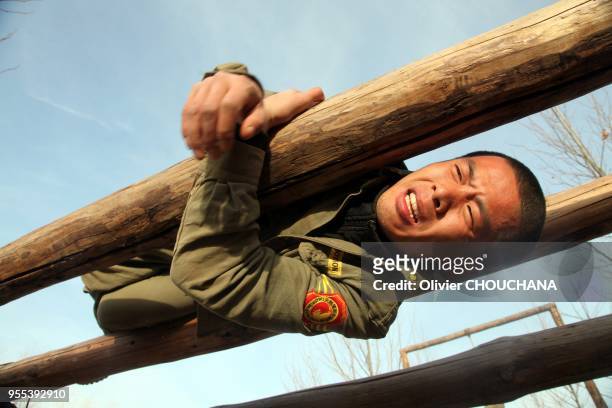 De jeunes recrues durant un entrainement intensif au métier de garde du corps dans un centre de formation de la banlieue de Pékin le 15 mars 2014 à...