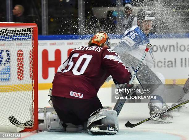 Finland's Mikko Rantanen stops by Latvia's goalkeeper Kristers Gudlevskis during the group B match Latvia vs Finland of the 2018 IIHF Ice Hockey...
