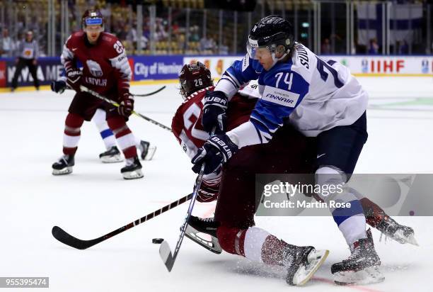 Uvis Balinskis of Latvia and Antti Suomela of Finland battle for the puck during the 2018 IIHF Ice Hockey World Championship group stage game between...