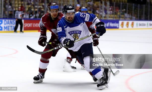 Ralfs Freibergs of Latvia skates against Pekka Jormakka of Finland battle for the puck during the 2018 IIHF Ice Hockey World Championship group stage...