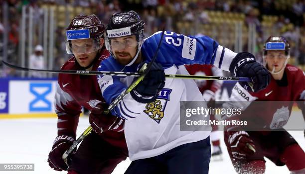 Ralfs Freibergs of Latvia battles for with Pekka Jormakka of Finland during the 2018 IIHF Ice Hockey World Championship group stage game between...
