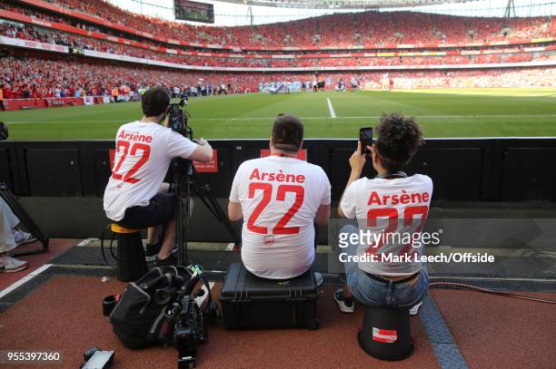 Television camera crew wearing shirts with a tribute to the Arsenal manager Arsene Wenger and his twenty-two years service during the Premier League...