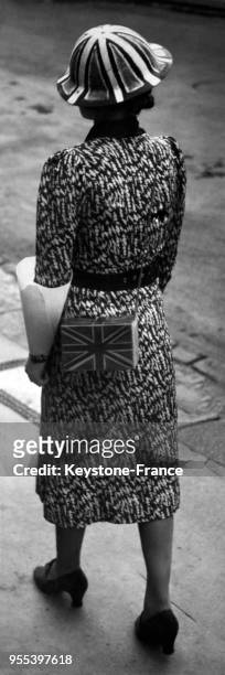 Une jeune femme marchant dans la rue porte un sac à main aux couleurs du drapeau britannique, à Londres, Royaume-Uni.