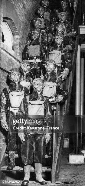 Hommes vêtus de combinaisons de protection et munis de masques à gaz, à Londres, Royaume-Uni.